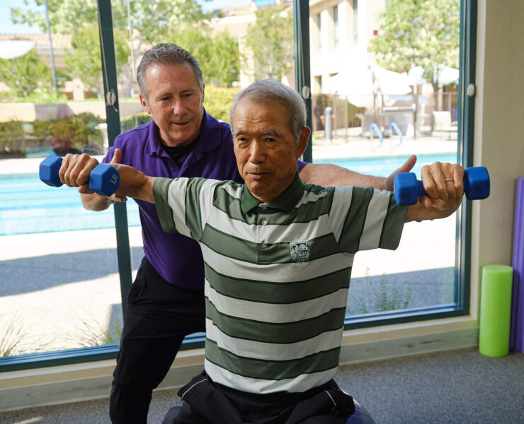 trainer helping resident exercise
