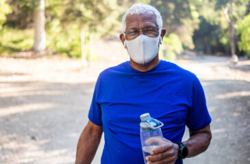 Man with mask on holding water