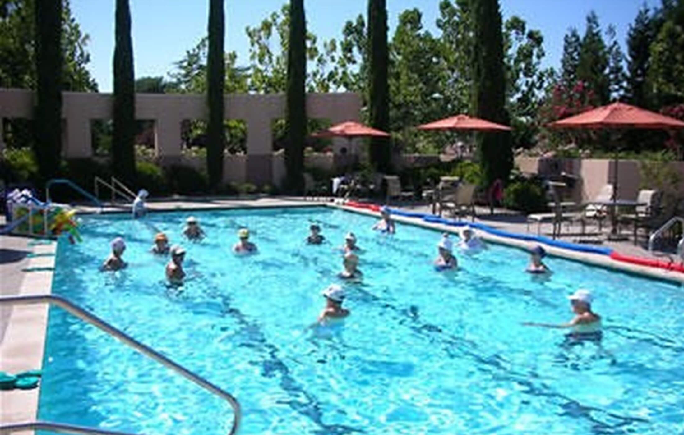 A photo of mature adults swimming in a private pool