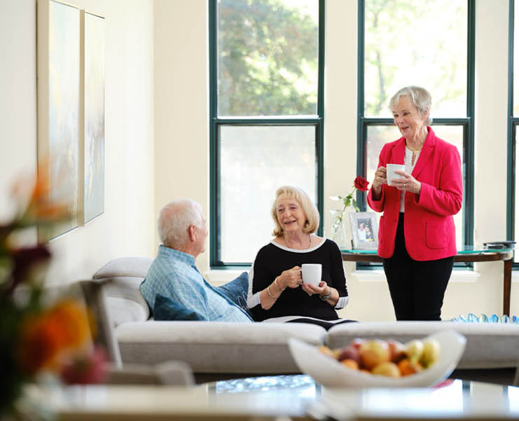 Seniors gather in a meeting area with coffee