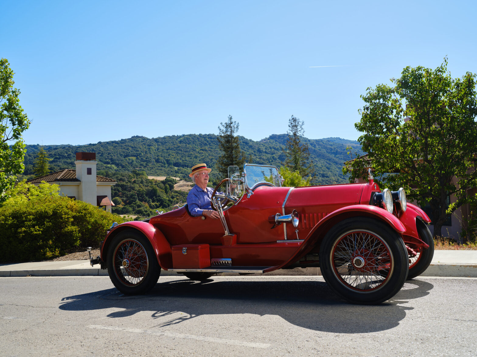 A senior man drives an classic car