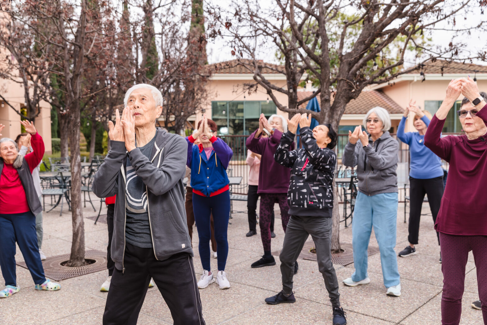 A group of active older adults meet outside of the The Forum retirement community for group exercise class